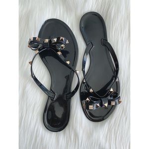 Studded black jelly bow flip flops